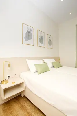 a white bedroom with a bed and a night stand at Callisto House in Kalyves in Kalyves