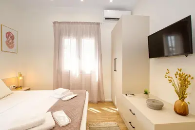 a white bedroom with a large bed and a window at Callisto House in Kalyves in Kalyves