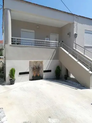 a white house with stairs and potted plants at Callisto House in Kalyves in Kalyves