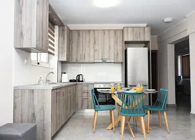 a kitchen with wooden cabinets and a table with chairs at eleftheria's apartment in Chania Town