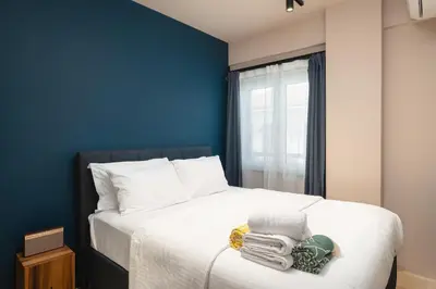a bedroom with a bed with a blue wall at D-Loft Chania in Chania Town