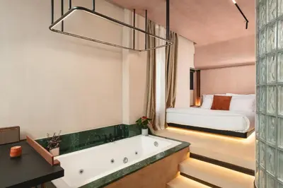 a bathroom with a bath tub and a bed at D-Loft Chania in Chania Town