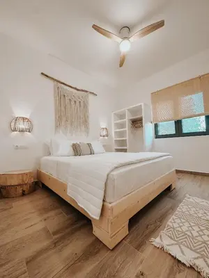 a bedroom with a large bed and a ceiling fan at Stella's Boho Retreat in Palaiochóra