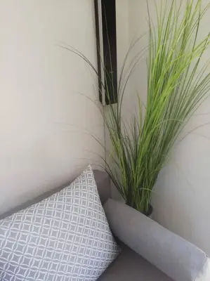 a pillow and a plant next to a wall at Enjoy Chania in Chania Town