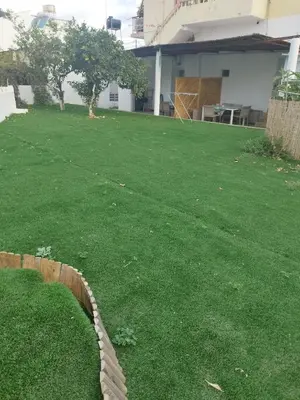 a yard with a rope laying on the grass at Kalyves Pearl apartments by the sea in Kalyves