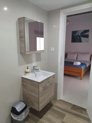 a bathroom with a sink and a bedroom with a bed at Kalyves Pearl apartments by the sea in Kalyves