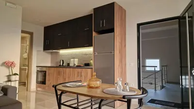 a kitchen with a table with chairs and a refrigerator at S n G/ Best view apartment in Kissamos