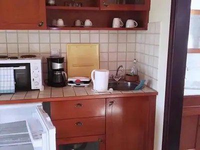 a kitchen counter with a sink and a microwave at Group accommodation in Crete separate houses in Douliana