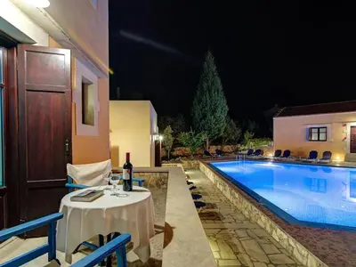 a table and chairs next to a swimming pool at Group accommodation in Crete separate houses in Douliana