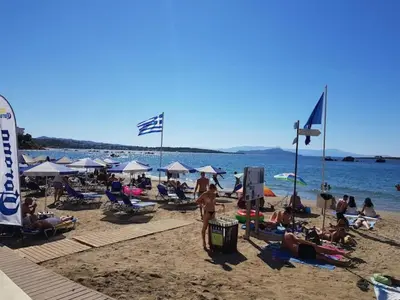a crowd of people on a beach with umbrellas at Cozy Studio in the Heart of Chania in Chania Town