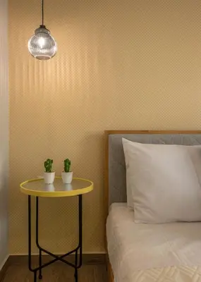 a table with two plants on it next to a bed at MAGNOLIA Luxury Chania Central Apartments in Chania Town