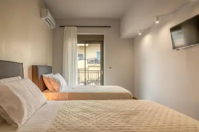 two beds in a room with a window at MAGNOLIA Luxury Chania Central Apartments in Chania Town