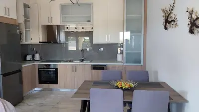 a kitchen with a table with chairs and a sink at Ioanna Apartment 1 in Chania Town
