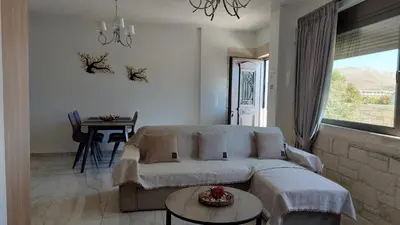a living room with a couch and a table and a window at Ioanna Apartment 1 in Chania Town