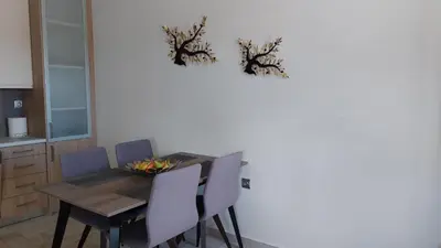 a dining room with a table with chairs and a wall at Ioanna Apartment 1 in Chania Town
