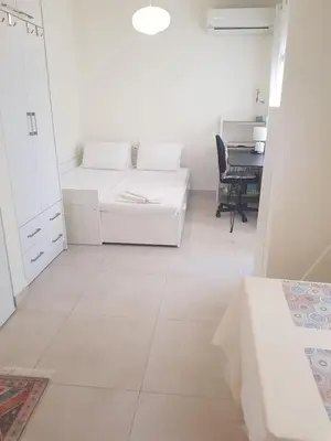 a white room with a bed and a desk at happy travelers studio free parking in Chania Town