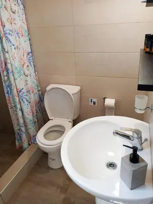 a bathroom with a toilet and a sink at happy travelers studio free parking in Chania Town