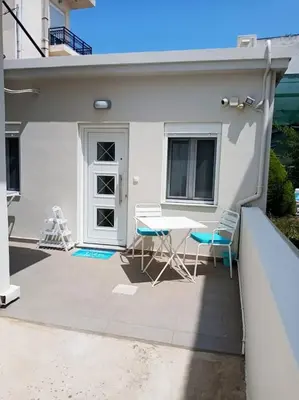 a patio with a table and chairs in front of a house at happy travelers studio free parking in Chania Town