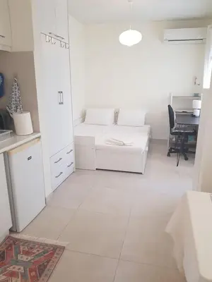 a white room with a bed and a table at happy travelers studio free parking in Chania Town