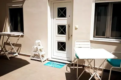 a front door with a table and chairs and a ladder at happy travelers studio free parking in Chania Town