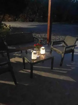 a table with a chair and a bench and a table with flowers at Anastasia’s Home in Chania Town
