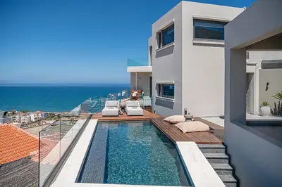 a villa with a swimming pool and a view of the ocean at Alectrona Living Crete, Apartment Olīvea in Plataniás