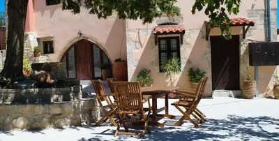a wooden table and chairs in front of a building at Mouri Villa in Mouríon
