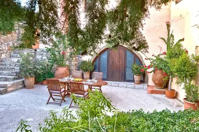 a patio with a table and chairs in front of a building at Mouri Villa in Mouríon