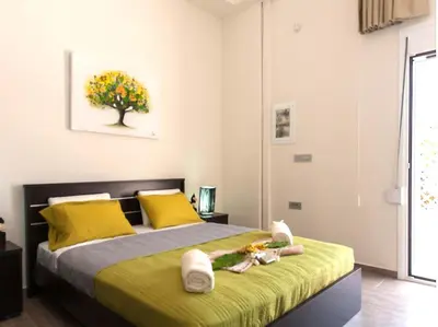 a bedroom with a large bed with yellow pillows at Green Orange Villa near Platanias in Chania Town