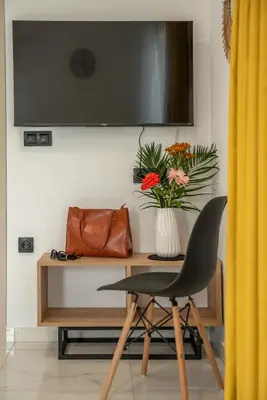a desk with a chair and a vase of flowers at Lysithea Apartments - brand new, stylish & central in Kissamos