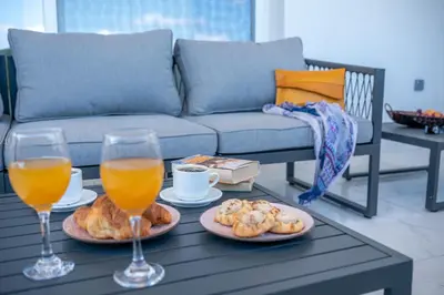 a coffee table with two glasses of orange juice and pastries at Lysithea Apartments - brand new, stylish & central in Kissamos