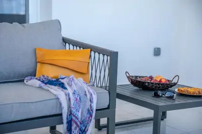 a couch and a table with a bowl of fruit at Lysithea Apartments - brand new, stylish & central in Kissamos