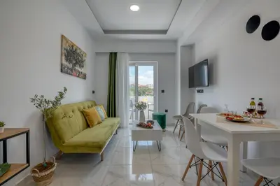 a living room with a green couch and a table at Lysithea Apartments - brand new, stylish & central in Kissamos