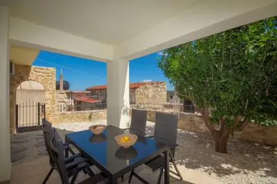 a blue table and chairs on a patio with a tree at Elma's Villa in Kissamos