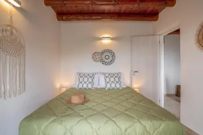 a bedroom with a green bed with a hat on it at Elma's Villa in Kissamos
