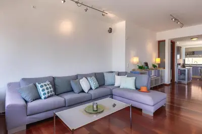 a living room with a blue couch and a table at Unlimited Blue in Chania Town