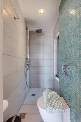 a bathroom with a tub and a shower with a toilet at Unlimited Blue in Chania Town