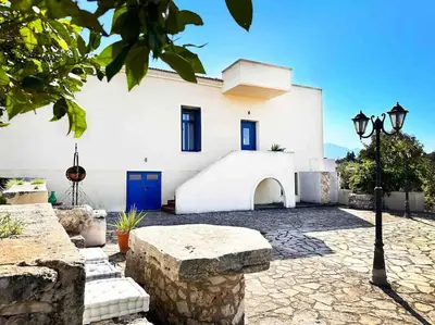 a white building with a blue door and a street light at Villa Xanthippe in Vamos