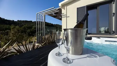 two wine glasses sitting on a table next to a bucket at Ek Ornelakis, Luxury Country House with Jacuzzi in Chania Town