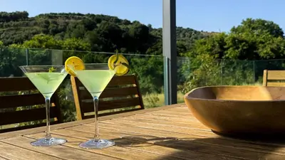 two martini glasses on a wooden table with a bowl at Ek Ornelakis, Luxury Country House with Jacuzzi in Chania Town