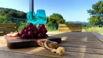 a table with two wine glasses and a bunch of fruit at Ek Ornelakis, Luxury Country House with Jacuzzi in Chania Town