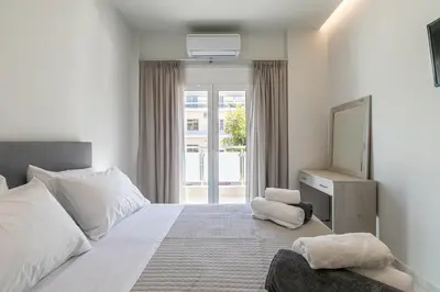 a bedroom with a large bed and a television at Neaira City Apartment Near The Beach in Chania Town