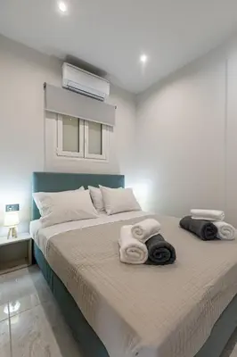 a bedroom with a bed with towels on it at Neaira City Apartment Near The Beach in Chania Town