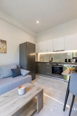 a living room with a couch and a table at Neaira City Apartment Near The Beach in Chania Town