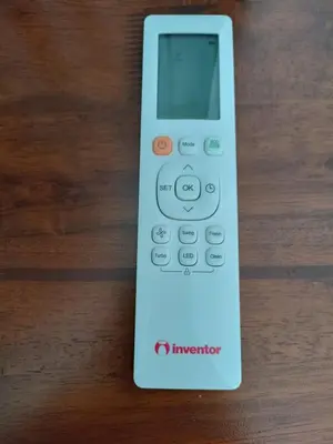 a white remote control sitting on a wooden table at The blackbird's nest in Chania Town