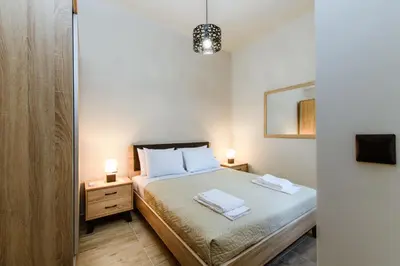a bedroom with a bed with two night stands and two lamps at Krinis houses next the old harbour in Chania Town