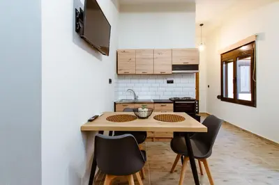 a small kitchen with a wooden table and chairs at Krinis houses next the old harbour in Chania Town
