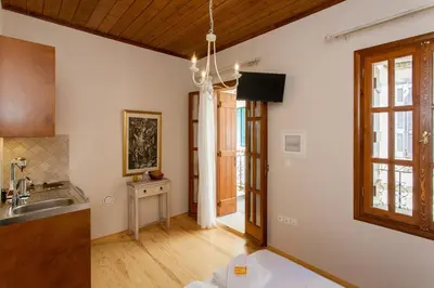 a kitchen with white walls and a wooden ceiling at Pleiades Apartments in Chania Town