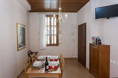 a dining room with a table and a television at Pleiades Apartments in Chania Town