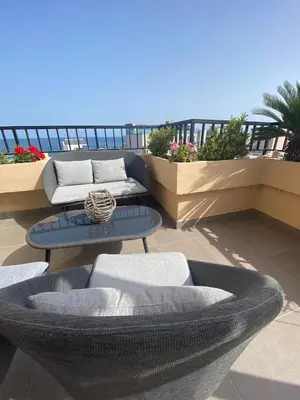 a patio with couches and tables on a balcony at Candia Hotel in Chania Town